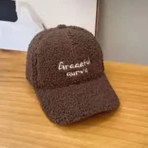 Close-up of deep brown Sherpa baseball cap with white Graceful Curve embroidery