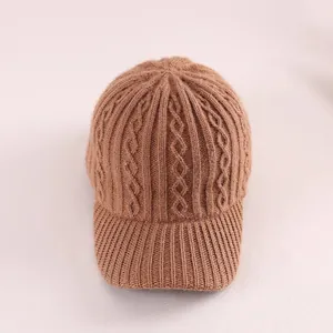 Detailed cable knit pattern on camel-colored winter baseball cap with ribbed brim