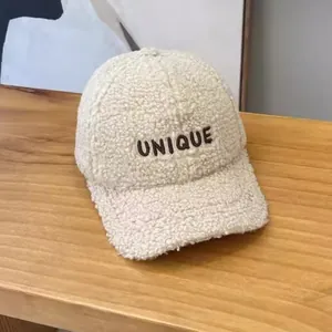 Off-white faux shearling baseball cap with UNIQUE embroidery on a wood surface