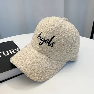 Close-up of beige Sherpa baseball cap featuring black Angels embroidery and fuzzy texture