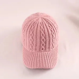 Close-up of pink cable knit baseball cap showing detailed winter fabric textures