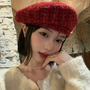 Detailed texture of red and black plaid wool tweed beret on a fashion model