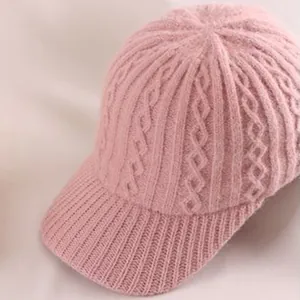Close-up of pink knit baseball cap with cable pattern and ribbed texture detail