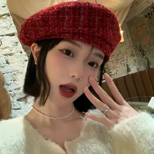 Detailed texture of red plaid wool tweed beret with elegant vintage weaving pattern