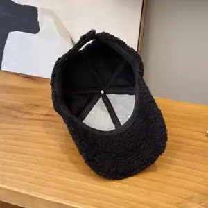 Detail view of the soft black sherpa baseball cap showing interior lining and adjustable strap