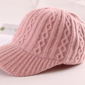 Close-up of pink cable knit texture on a winter baseball cap with soft wool feel