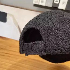 Detail of black sherpa fleece baseball cap showing textured fabric and adjustable back