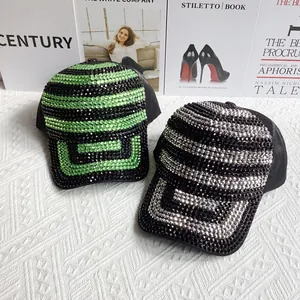 Détail de casquettes de baseball en strass avec motifs géométriques verts et argentés