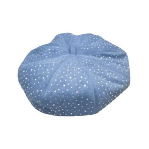 Washed denim beret for women with sparkling rhinestones on a light blue fabric background