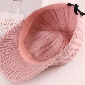 Internal view of pink knitted baseball cap with ribbed texture and adjustable strap