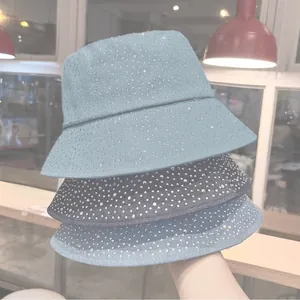 Detailed view of rhinestone embellishments on three shades of denim bucket hats