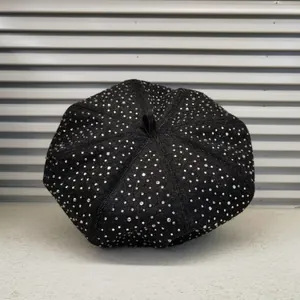 Detail of black denim beret with sparkling silver rhinestones and top fabric loop