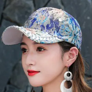 Close-up of floral jacquard baseball cap with sparkling rhinestones and metallic thread
