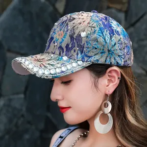 Detailed view of floral embroidery and sparkling rhinestones on a stylish sun baseball cap