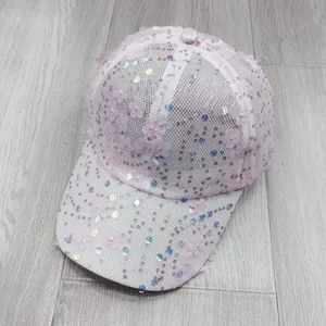 Detailed close-up of white mesh baseball cap with pink flower appliques and shiny sequins
