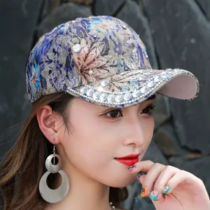 Detail of floral jacquard baseball cap with sparkling rhinestones and fabric texture