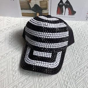 Détail d'une casquette de baseball noire avec rayures en strass et motifs en cristaux