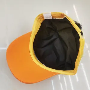 Vue détaillée de l'intérieur de la casquette avec étiquette et texture en coton orange