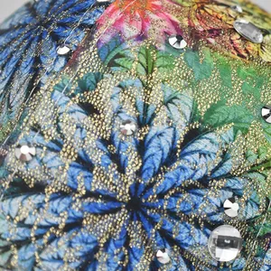Macro shot of colorful floral print fabric with gold glitter and sparkling rhinestones detail