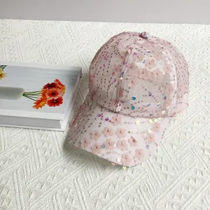 Detail of light pink mesh baseball cap featuring 3D plum blossom sequins and floral texture