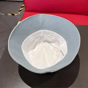 Detailed interior view of light blue denim bucket hat showing white lining and stitching