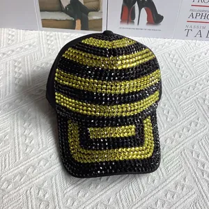 Détail d'une casquette de baseball noire avec des strass jaunes et noirs sur la visière