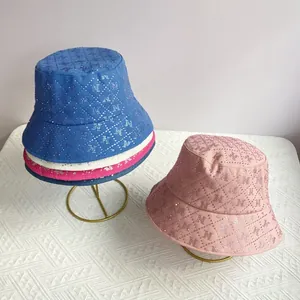 Detail of quilted bucket hat with rhinestone H patterns on gold display stand