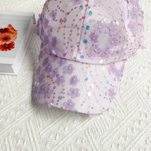 Detail of light purple floral appliqué and sequins on breathable white mesh baseball cap