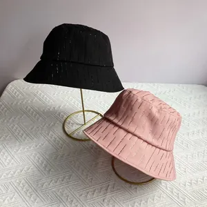 Detailopname van zwarte en roze vissershoeden met glinsterende strass-strepen