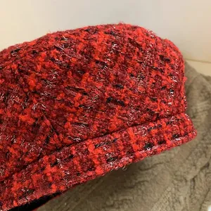 Macro detail of red wool tweed beret with metallic silver and black glitter weaving