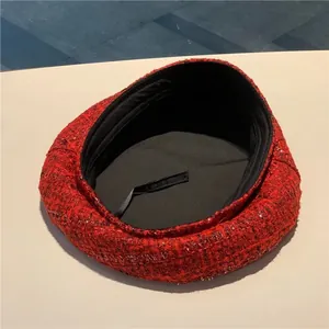 Close-up of red tweed beret showing wool texture, black lining and adjustable drawstring