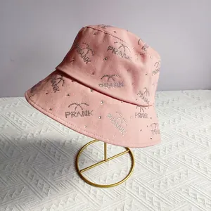 Detailed close-up of pink bucket hat with sparkly rhinestone patterns and PRANK lettering
