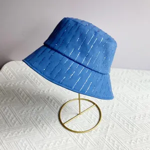 Detail van donkerblauwe vissershoed met verticale zilveren strass-strepen op een standaard