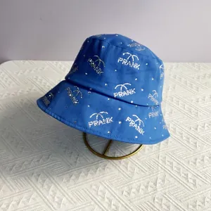 Detail of blue bucket hat featuring rhinestone PRANK lettering and palm tree design