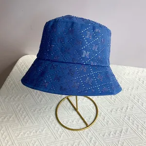 Detail of royal blue bucket hat with sparkling rhinestone N pattern and wide brim