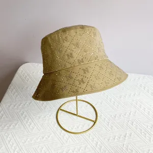 Detail of khaki wide brim bucket hat with rhinestone letter N and diamond pattern