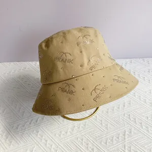 Close-up of khaki bucket hat with sparkling rhinestone PRANK letters and wide brim
