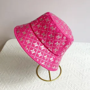 Macro detail of rhinestone M patterns and diamond stitching on pink sun hat