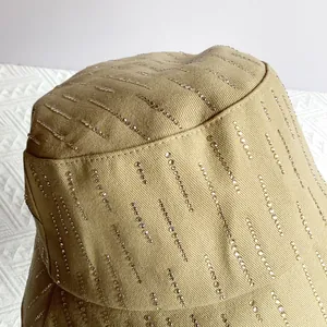 Macro-opname van glinsterende strass-steentjes op een kaki katoenen visserhoedje detail