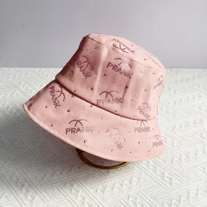 Detailed view of pink cotton bucket hat featuring sparkling rhinestone letters and palm trees