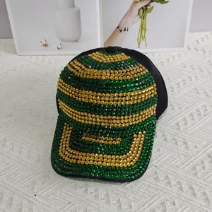 Détail d'une casquette de luxe avec strass verts et dorés sur tissu noir élégant