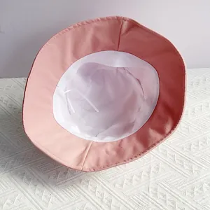 Detailed interior of pink cotton bucket hat with white adjustable drawstrings and lining