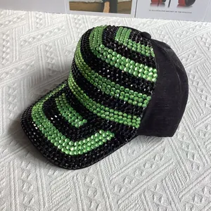 Détails de luxe des strass verts sur une casquette de baseball noire à rayures