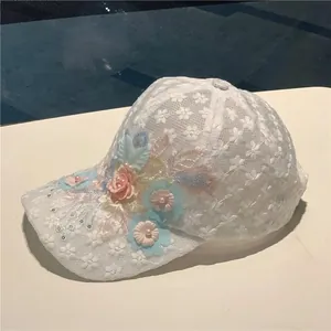 Detailed view of floral lace baseball cap with handmade flowers and pearl sequins