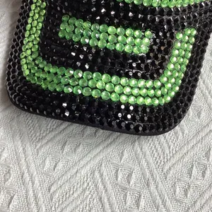 Vue détaillée des strass bicolores noir et vert fluo sur la visière de la casquette