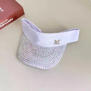 Close-up of light purple sun visor with crystal-encrusted brim and silver M logo