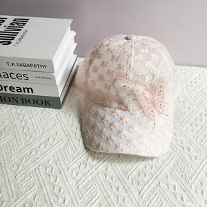 Dettaglio cappellino in pizzo rosa con farfalla 3D decorata con perle e perline
