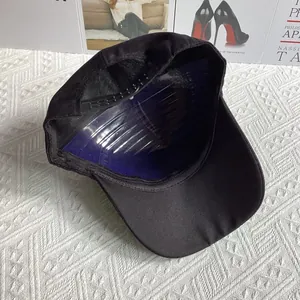 Détail de la casquette noire montrant la sangle réglable et la doublure intérieure soignée