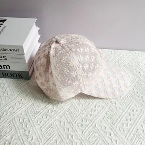 Dettaglio della cuffia da baseball in pizzo rosa con ricami floreali e rete mesh
