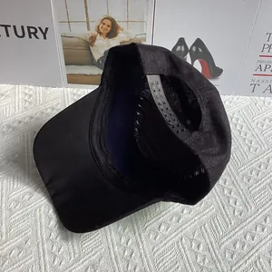 Détail de la fermeture snapback réglable et couture intérieure sur casquette noire